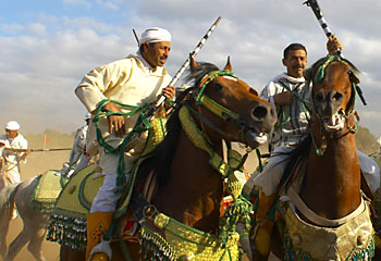 Desert ... colourfast dyes have removed the indigo edge from Berber tribesmen, on horseback, famously known as the 'blue men' of the desert / Ewan Bell