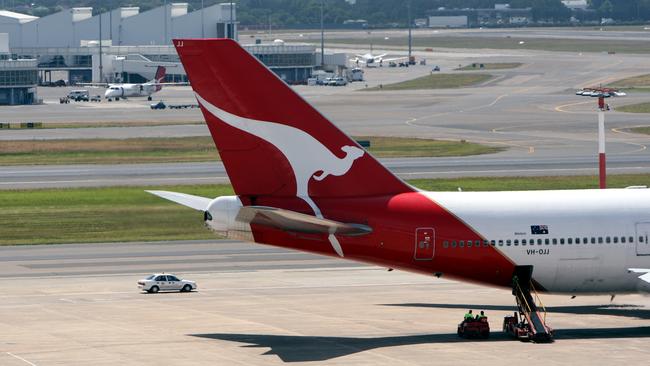 Flying Kangaroo logo on tail of a Qantas jet at International Airport in Sydney.