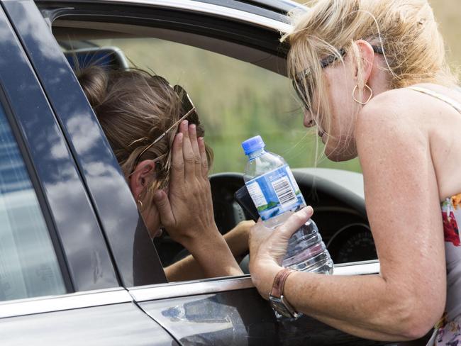 A woman consoles her pregnant daughter and grandchildren after they left the small town of Hoskinstown. The woman's husband was unable to leave their property. Picture: Sean Davey