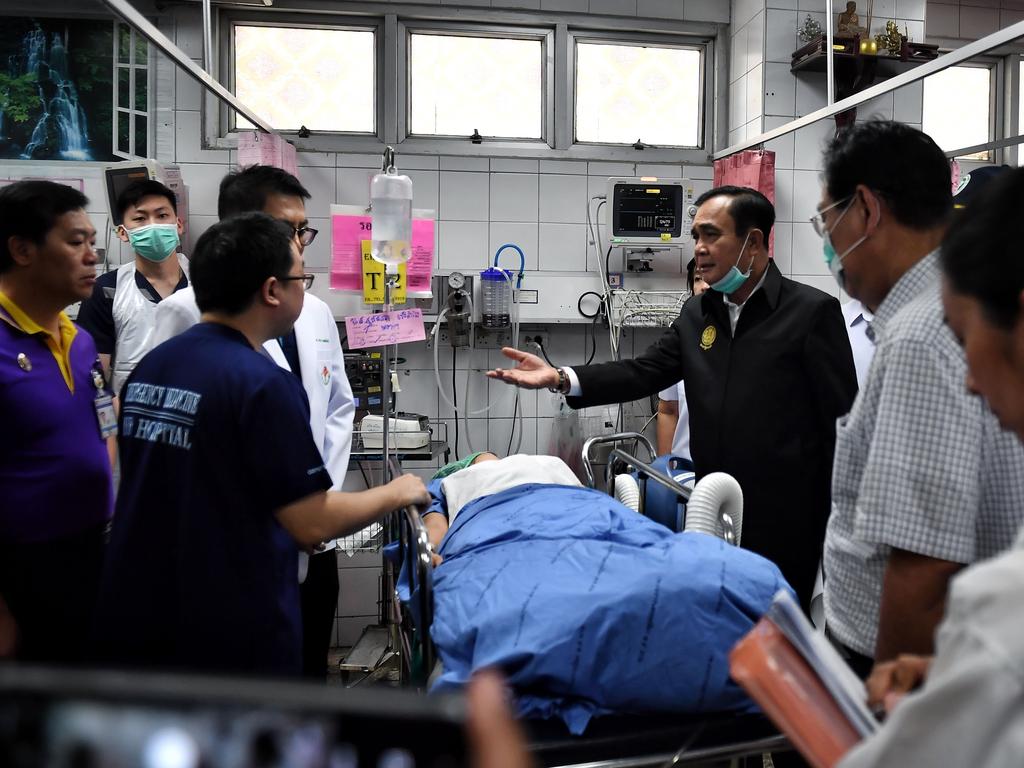 Thailand’s Prime Minister Prayut Chan-O-Cha (dark jacket) visiting one of the survivors of the shooting at the Terminal 21 shopping mall at the Maharat Nakhon Ratchasima Hospital. Picture: Lillian Suwanrumpha/AFP