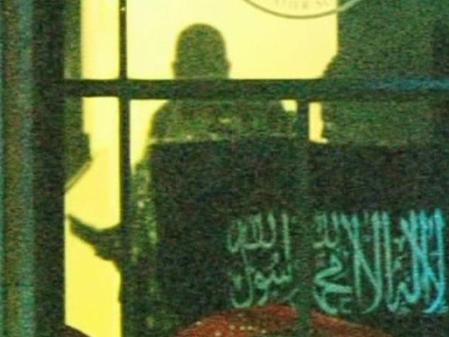 Channel 7 screen grabs of the Lindt Martin Place terror hostage. Muslim flag at the window, sniper