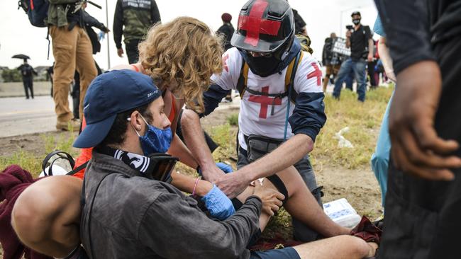 People help a man who was shot after a car sped through a crowd of protesters in Denver. Picture: Getty Images/AFP