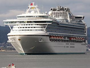 A small tinny hurries to move out of the way of the Diamond Princess as it heads into port.