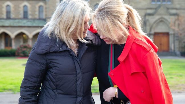 School mothers Janet Mitchell and Sam Baker comfort each other after the announcement. Picture: Sarah Matray