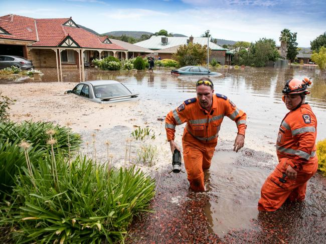 SES workers connect a pumping line to begin removing the water flooding homes in Willow Dr after the burst water main eight months ago. Picture: Russell Millard