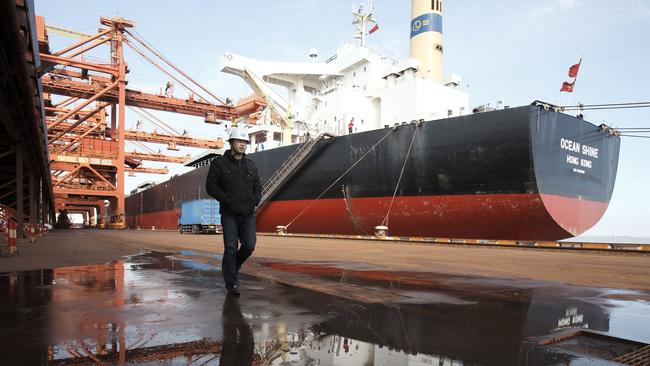 A man walks near a bulk carrier cargo ship docked at an iron-ore transfer and storage center in Shanghai. Picture: Qilai Shen/Bloomberg