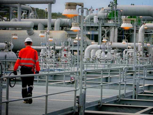 A worker walks through a plant at the Queensland Curtis Liquefied Natural Gas (QCLNG) project site, operated by QGC Pty, a unit of Royal Dutch Shell Plc, in Gladstone, Australia, on Wednesday, June 15, 2016. Gas from more than 2,500 wells travels hundreds of miles by pipeline to the project, where it's chilled and pumped into 10-story-high tanks before being loaded onto massive ships. Photographer: Patrick Hamilton/Bloomberg