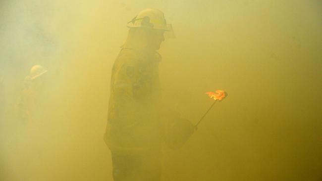 NSW Rural Fire fighters establish a backburn ton contain a fire in Mangrove Mountain on Sunday. Picture: AAP/Jeremy Piper