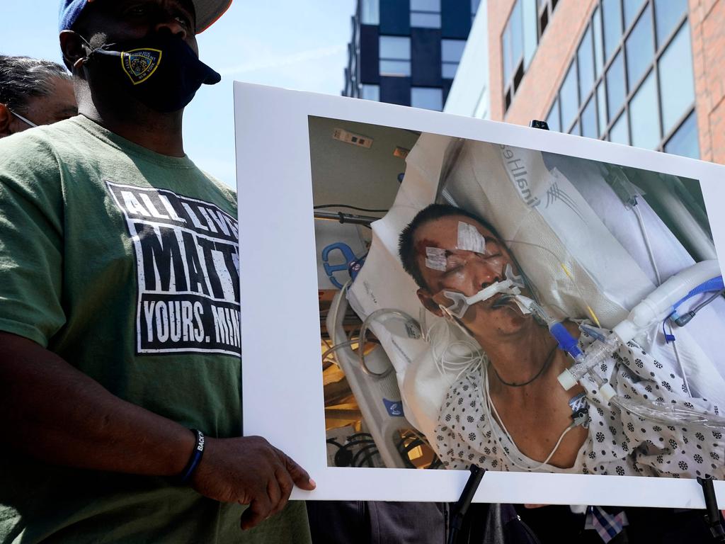 People hold a photo of 61-year old Yao Pan Ma who was was attacked in Harlem. Picture: Timothy A. Clary/AFP