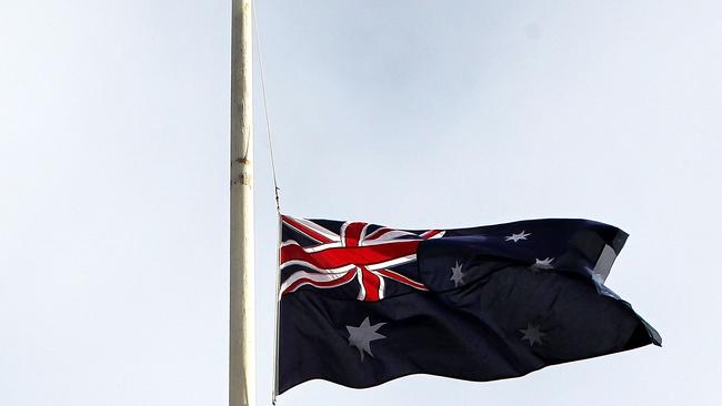 An Australian flag flies at half-mast as a sign of respect at Treasury Place in Melbourne