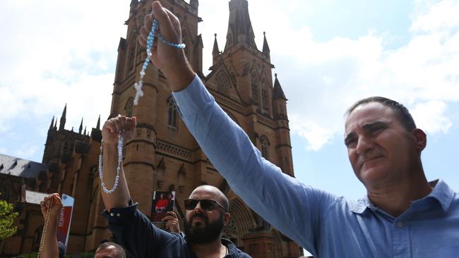 Catholic supporters signal towards protesters outside St. Mary’s Cathedral ahead of the pontifical requiem mass for Cardinal George Pell on February 02, 2023 in Sydney.