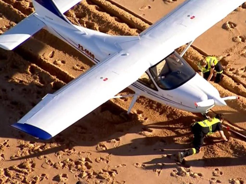 Workers appear to be clearing away sand from underneath the front of the aircraft that landed on Collaroy Beach. Picture: 7 News/Twitter