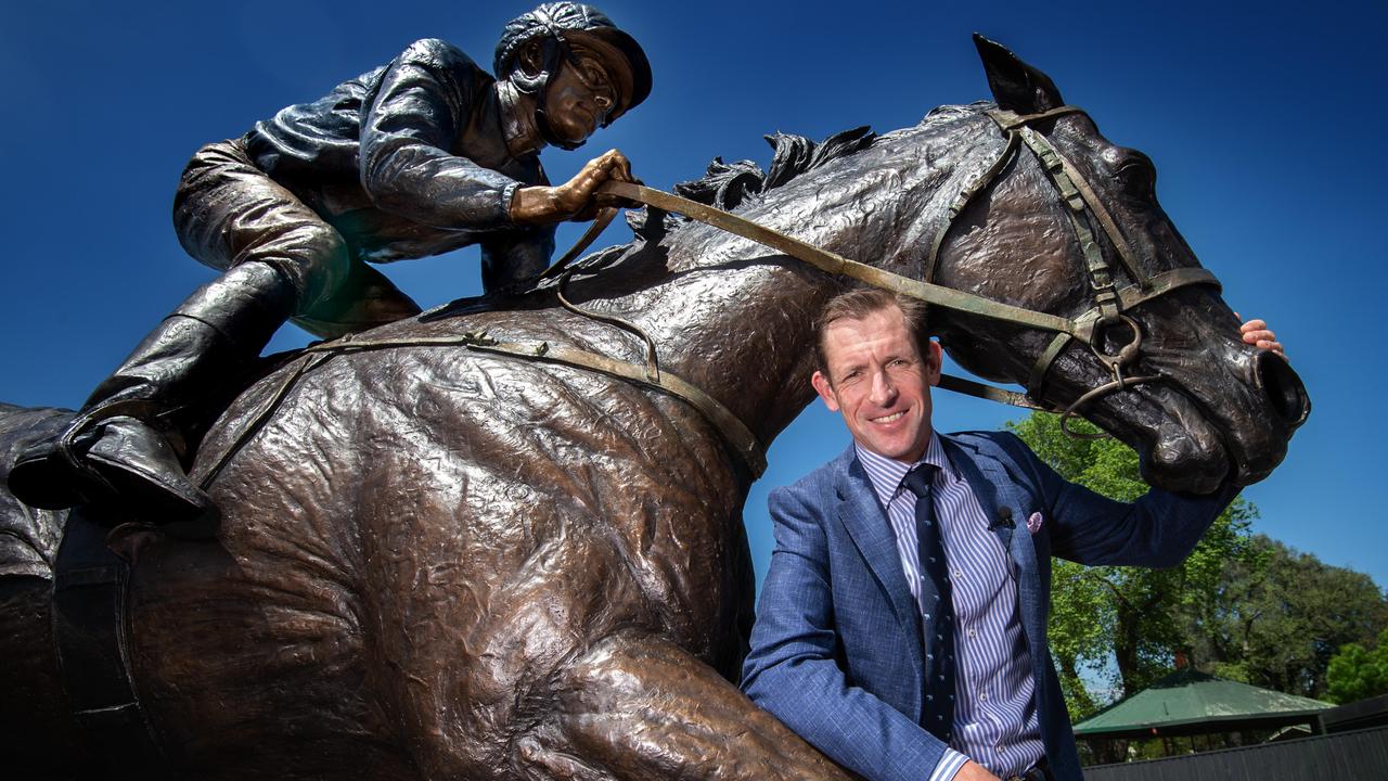 Hugh Bowman poses with a statue of Winx at The Valley. Picture: Tony Gough