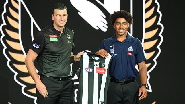 Isaac Quaynor is handed his Collingwood jumper by Simon Prestigiacomo. Picture: AAP