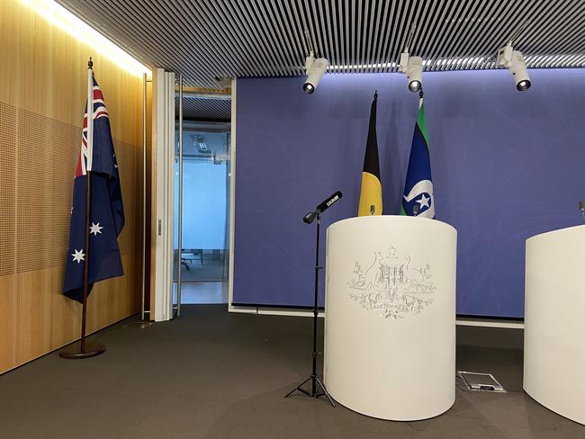 An Australian flag is moved to the side of the room prior to Greens leader Adam Bandt conducting a press conference.