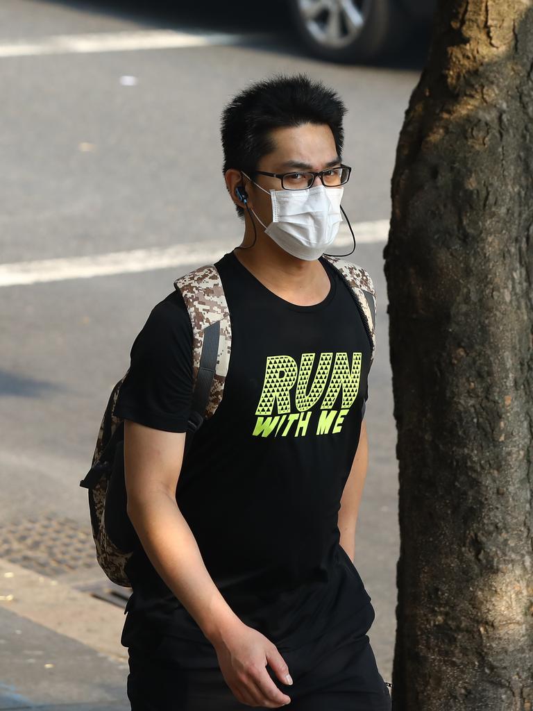 As smoke from bushfires engulfs Sydney, morning commuters are pictured wearing face masks as they make their way to work. Picture: MATRIX