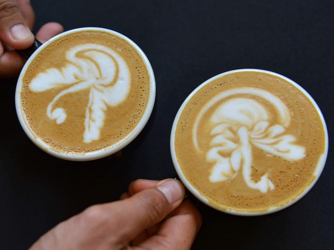 (FILES) In this file photo taken on October 20, 2019 Latte coffee baristas compete in a contest at the Aceh Coffee Festival in Banda Aceh on October 20, 2019. - Even though the demand for coffee is stronger than ever, with consumption climbing steadily, falling prices are disrupting production in some regions and leading to small producers abandoning the crop entirely, especially for the high-end Arabica variety. (Photo by CHAIDEER MAHYUDDIN / AFP)