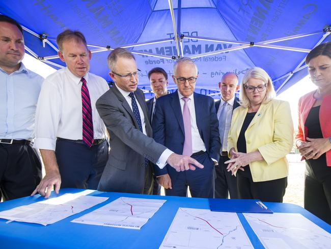 Prime Minister Malcolm Turnbull (centre) looks over plans for a M1 Pacific Motorway upgrade alongside local MPs. Picture: Glenn Hunt/AAP