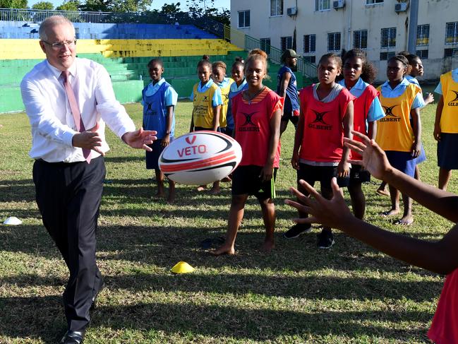 Mr Morrison played rugby with students from St Joseph's Tenaru School in Honiara. Picture: AAP