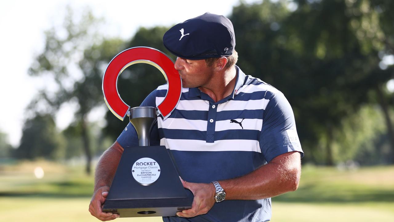 Bryson DeChambeau celebrates with the trophy.