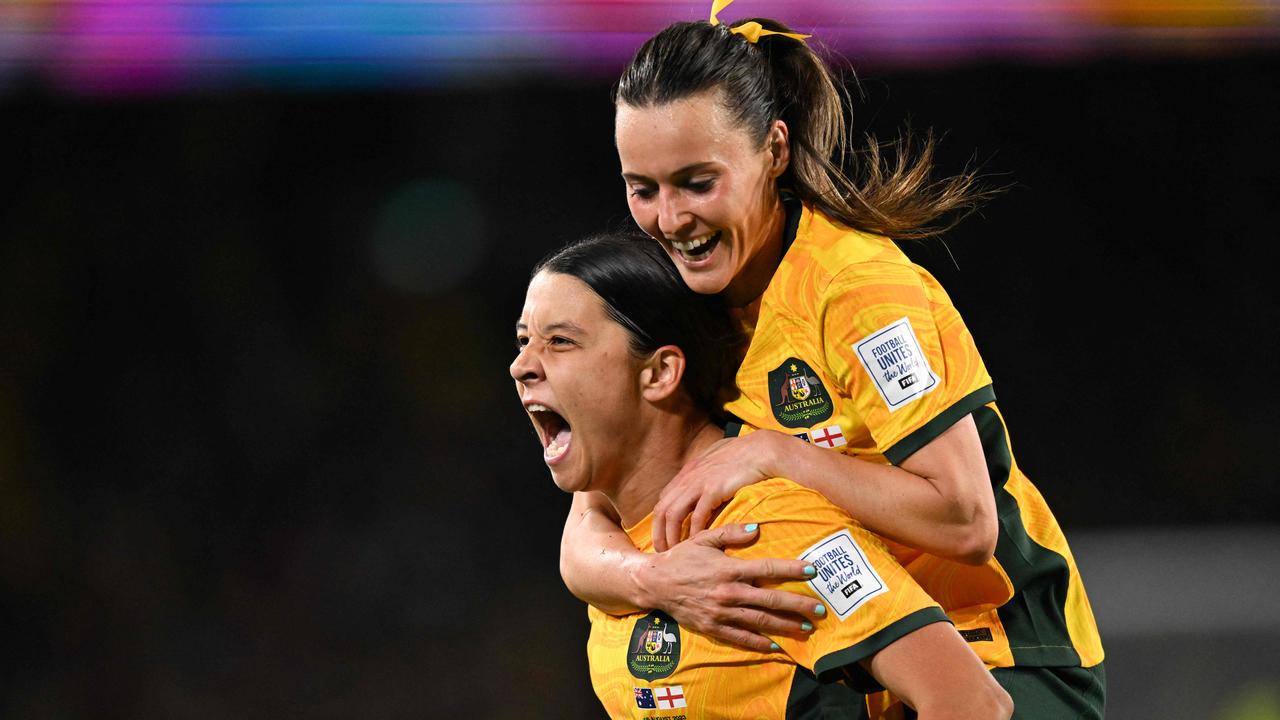 Australia's forward #20 Sam Kerr celebrates scoring her team's first goal with Australia's forward #16 Hayley Raso during the Australia and New Zealand 2023 Women's World Cup semi-final football match between Australia and England at Stadium Australia in Sydney on August 16, 2023. (Photo by Izhar KHAN / AFP)