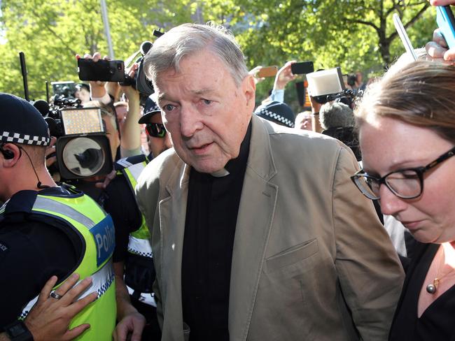 (FILES) This file photo taken on February 27, 2019 shows Australian Cardinal George Pell (C) making his way to the court in Melbourne. - Cardinal George Pell will walk free from jail after winning a long-running battle to overturn his child sex abuse convictions in Australia's High Court on April 7, 2020. (Photo by Con CHRONIS / AFP)