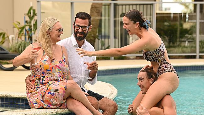 Dan Ceh, 45, and wife Terri Dempsey-Ceh, 46, with daughter Bella Dempsey-Ceh 21 and her partner Rhys Finn 24, at the pool at their apartment block in Burleigh Heads on the Gold Coast. They should be in Sydney on Christmas Day to spend time with Terri's sister and extended family. Picture: Lyndon Mechielsen