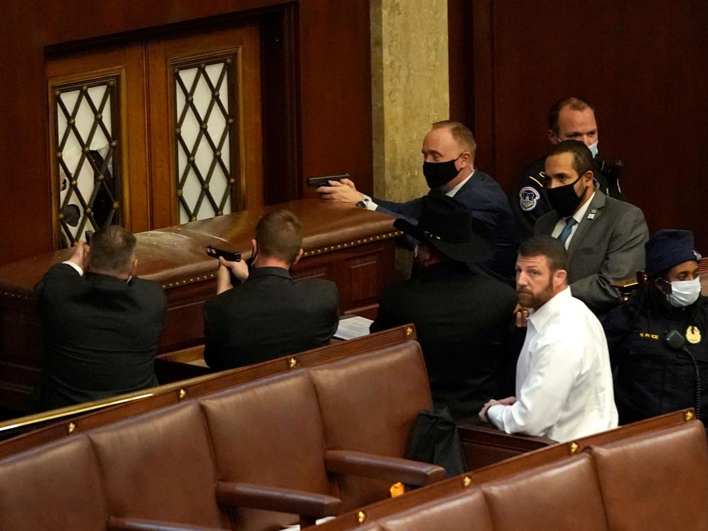 Police officers point their guns at a barricaded House Chamber door in scenes from the Capitol building. Picture: Drew Angerer/Getty/AFP