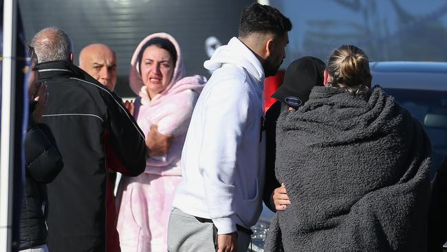 Friends and family members console each other. Picture: Brendan Beckett