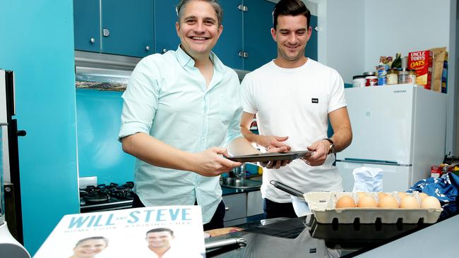 Will and Steve with their new cookbook, cooking up something in Steve's kitchen in Manly.