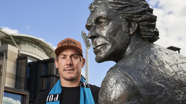 Brett Ebert next to the statue of his dad, Russell, at Adelaide Oval. Picture: Matt Loxton