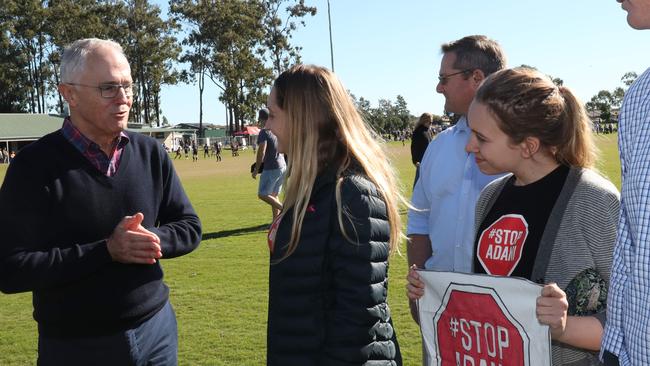 Prime Minister Malcolm Turnbull talks with anti-Adani protester Millie Anthony while campaigning in Caboolture this morning. Picture: Annette Dew