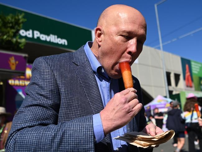 BRISBANE, AUSTRALIA - NewsWire Photos - AUGUST 10, 2022. Federal Leader of the Opposition Peter Dutton eats a Dagwood Dog as he visits the Ekka show at the RNA Showgrounds. Picture: NCA NewsWire / Dan Peled