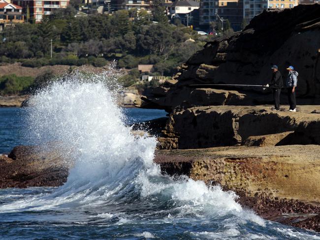 Fisherman on the rocks off at Clovelly beach headlands.