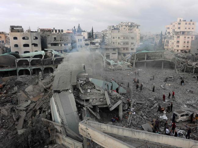 Palestinians check the devastation in the yard of a destroyed school, a day after it was hit by an Israeli strike, in the al-Tuffah neighbourhood of Gaza City. Picture: AFP