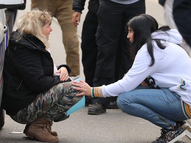 A woman kneels by a police car as she cries in the streets after a knife attack in Nice. Picture: AFP