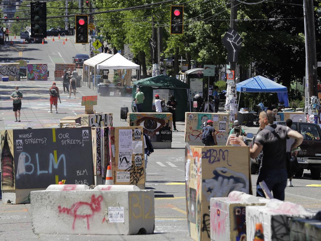 People walk amid barricades in what has been named the Capitol Hill Occupied Protest zone in Seattle on June 22. Picture: Ted S. Warren