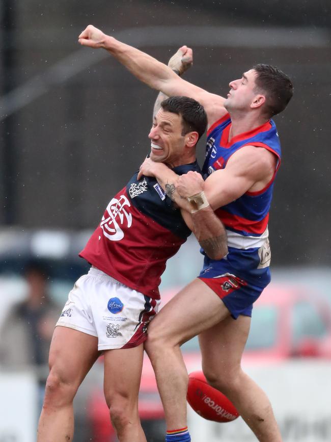 Gisborne’s Patrick Trotta fists the ball away from Sandhurst’s Brodie Montague.