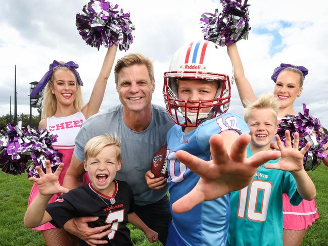 Super Bowl Monday Caulfield racecourse. Former AFL player Nick Riewoldt and his sons, James, Will and Teddy, flanked by two cheerleaders, on the straight at Caulfield. It's for a story on the racecourse hosting a Super Bowl Monday tailgate party as part of an NFL-themed summer carnival. Nick Riewoldt and his sons, James 10, Will 8 and Teddy 5, flanked by two cheerleaders Kelsey Jenning and Ashleigh Kempster on the track.                                                              Picture: David Caird