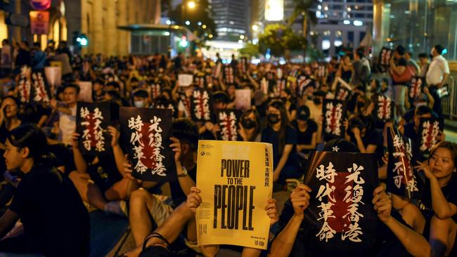 Pro-democracy protesters hold signs as they attend a rally in Hong Kong. Picture: Manan Vatsyayana/AFP