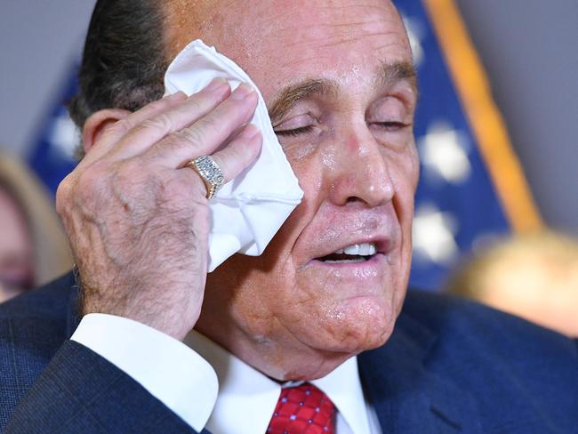 Mr Giuliani wipes away the dye. Picture: AFP