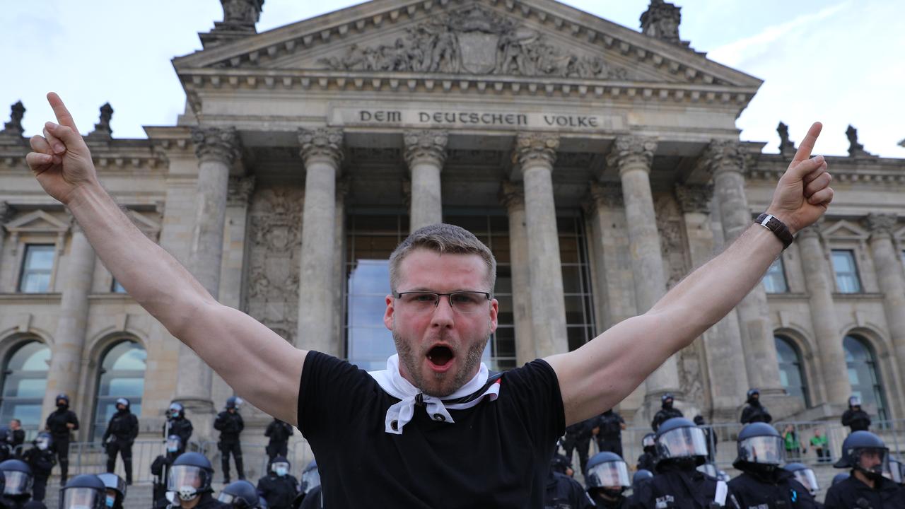 A protester in front of German riot police standing guard outside the Reichstag during protests against coronavirus-related restrictions and government policy on August 29, 2020 in Berlin. Picture: Omer Messinger/Getty Images