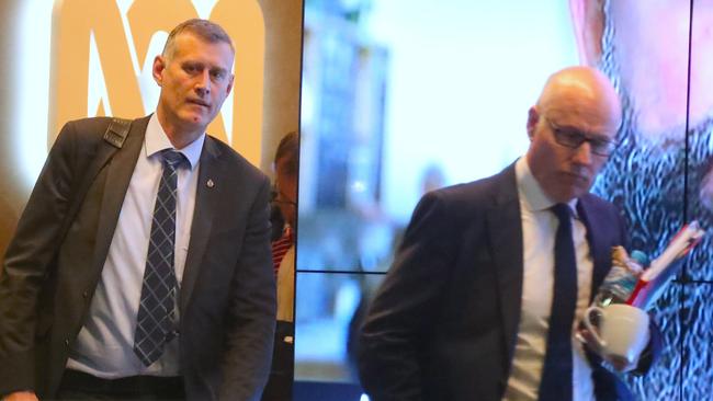 John Lyons (right), executive editor of ABC News, is followed out of the ABC building at Ultimo by an officer from the Australian Federal Police. Picture: AAP