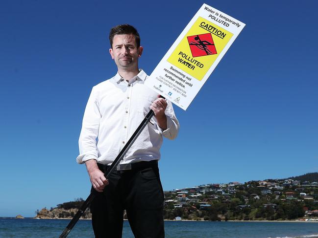 Kingborough Mayor Dean Winter with the warning sign at Blackmans Bay beach. Picture: NIKKI DAVIS-JONES