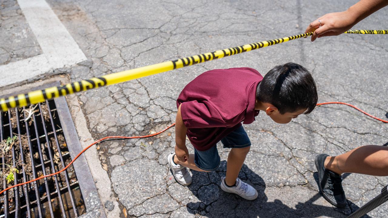 A child crosses under caution tape after the massacre at Robb Elementary School. Picture: Brandon Bell/Getty Images/AFP