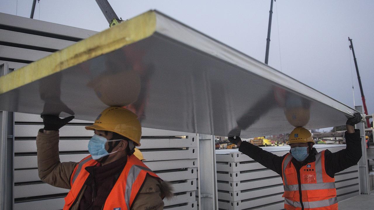 Workers carry construction material at Huoshenshan hospital. Picture: Getty Images