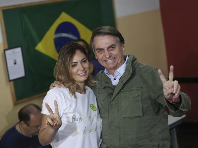 Jair Bolsonaro, presidential candidate with the Social Liberal Party, flashes a victory sign alongside his wife Michelle during the presidential runoff election in Rio de Janeiro, Brazil, Sunday, Oct. 28, 2018. Jair Bolsonaro is running against leftist candidate Fernando Haddad of the Workersâ€™ Party. (Ricardo Moraes/Pool Photo via AP)