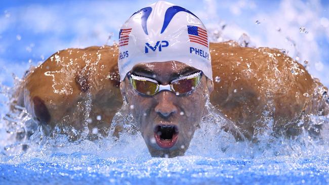 TOPSHOT - USA's Michael Phelps competes in a Men's 200m Butterfly heat during the swimming event at the Rio 2016 Olympic Games at the Olympic Aquatics Stadium in Rio de Janeiro on August 8, 2016. / AFP PHOTO / GABRIEL BOUYS