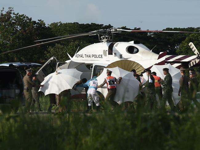 Thai police and military personnel use umbrellas to shield the fifth boy as he is evacuated by helicopter to a hospital in Chiang Rai. Picture: AFP