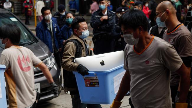 A national security policeman carries a computer during the raid on Stand News last week. Picture: AFP